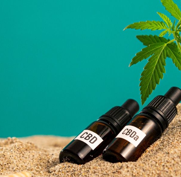 CBD- und CBA-Ölflaschen im Sand