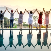 A row of happy people standing celebrating life on the edge of a pool