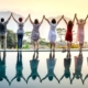 A row of happy people standing celebrating life on the edge of a pool