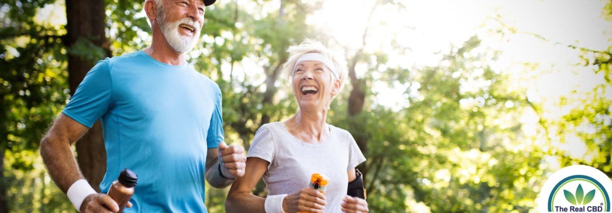 Vieux couple heureux courant dans la forêt