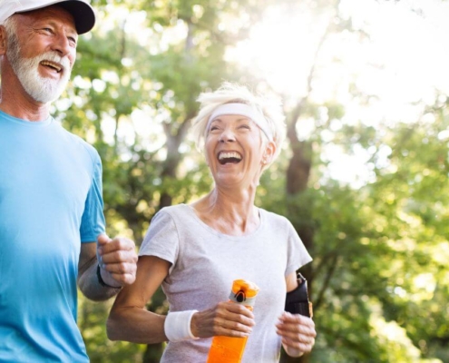 Vieux couple heureux courant dans la forêt