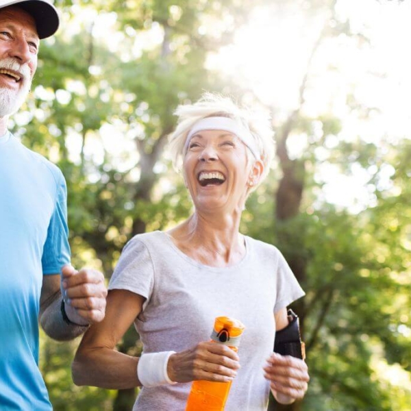 Happy old couple running in the forrest