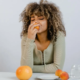 Woman enjoying a peach at a dinner table