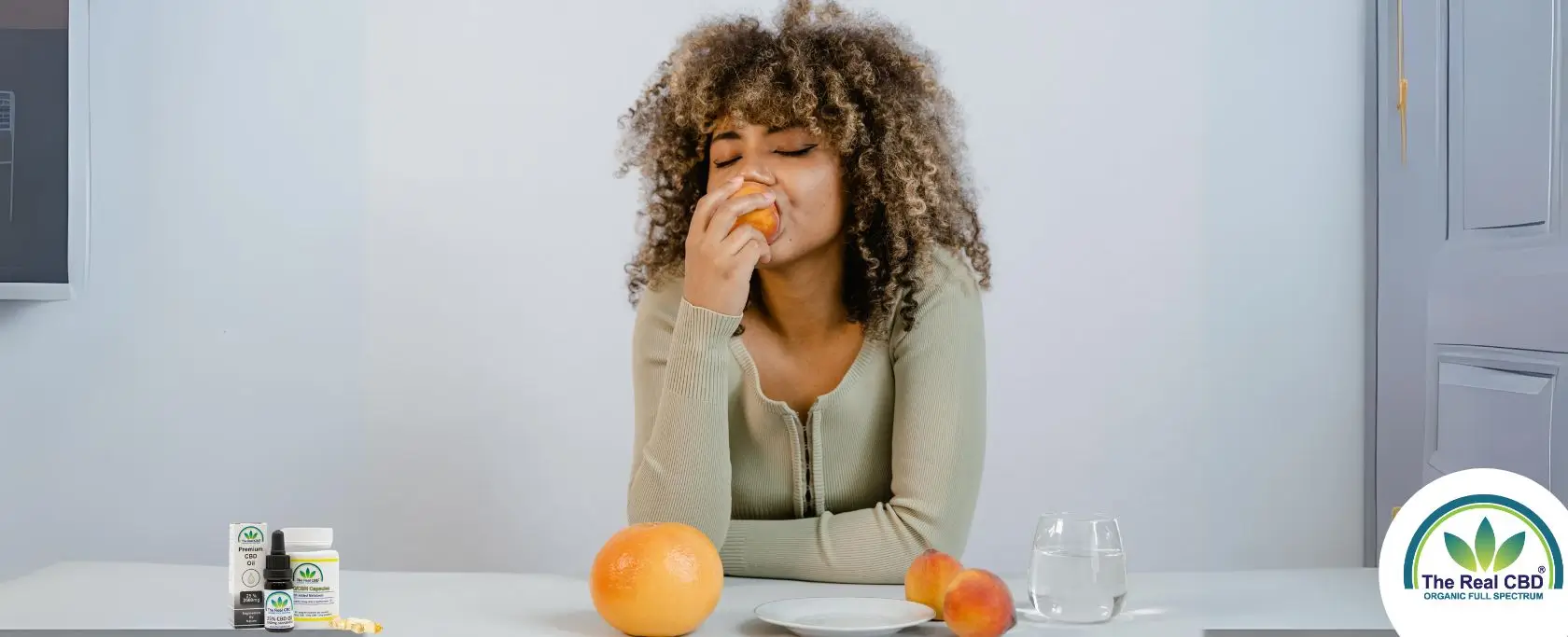 Woman enjoying a peach at a dinner table