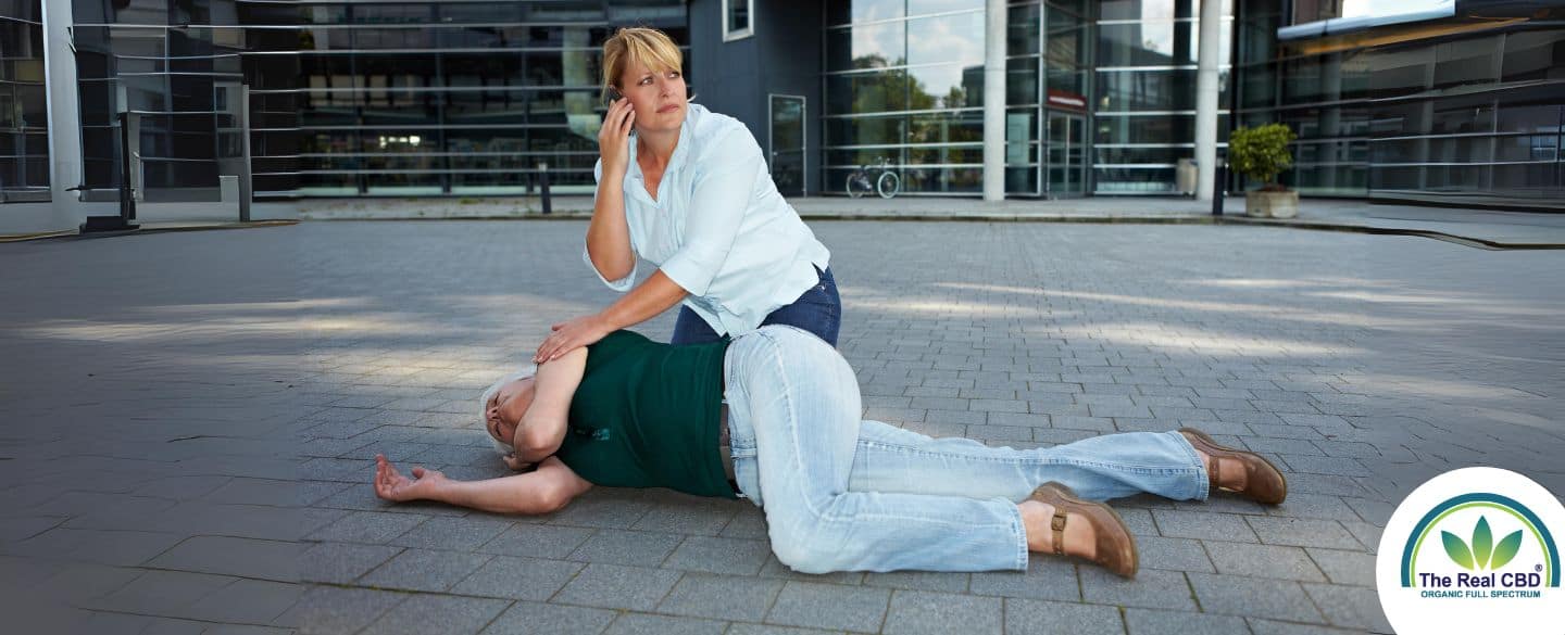 Woman calling for help for a person on the ground having a seizuer