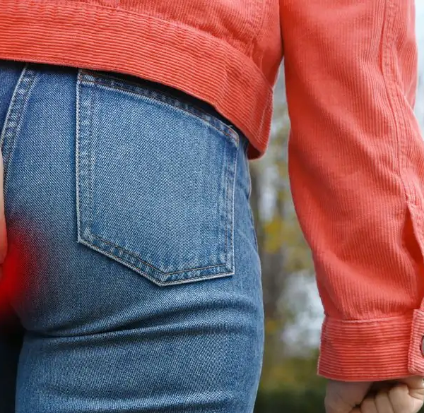 Woman walking up the stairs holding her butt