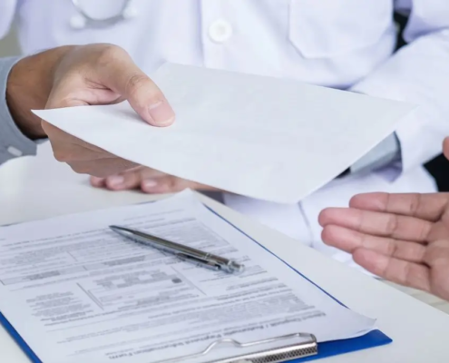 Doctor handing over a prescription to a patient