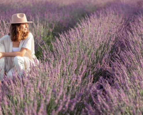 Woman sitting in a lavender field with her dog