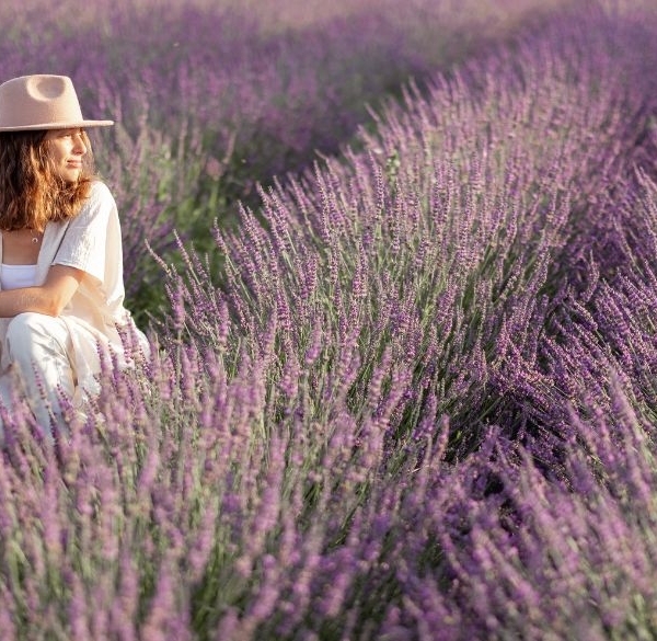 Woman sitting in a lavender field with her dog