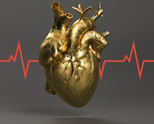 A gold human heart with EKG red line going through